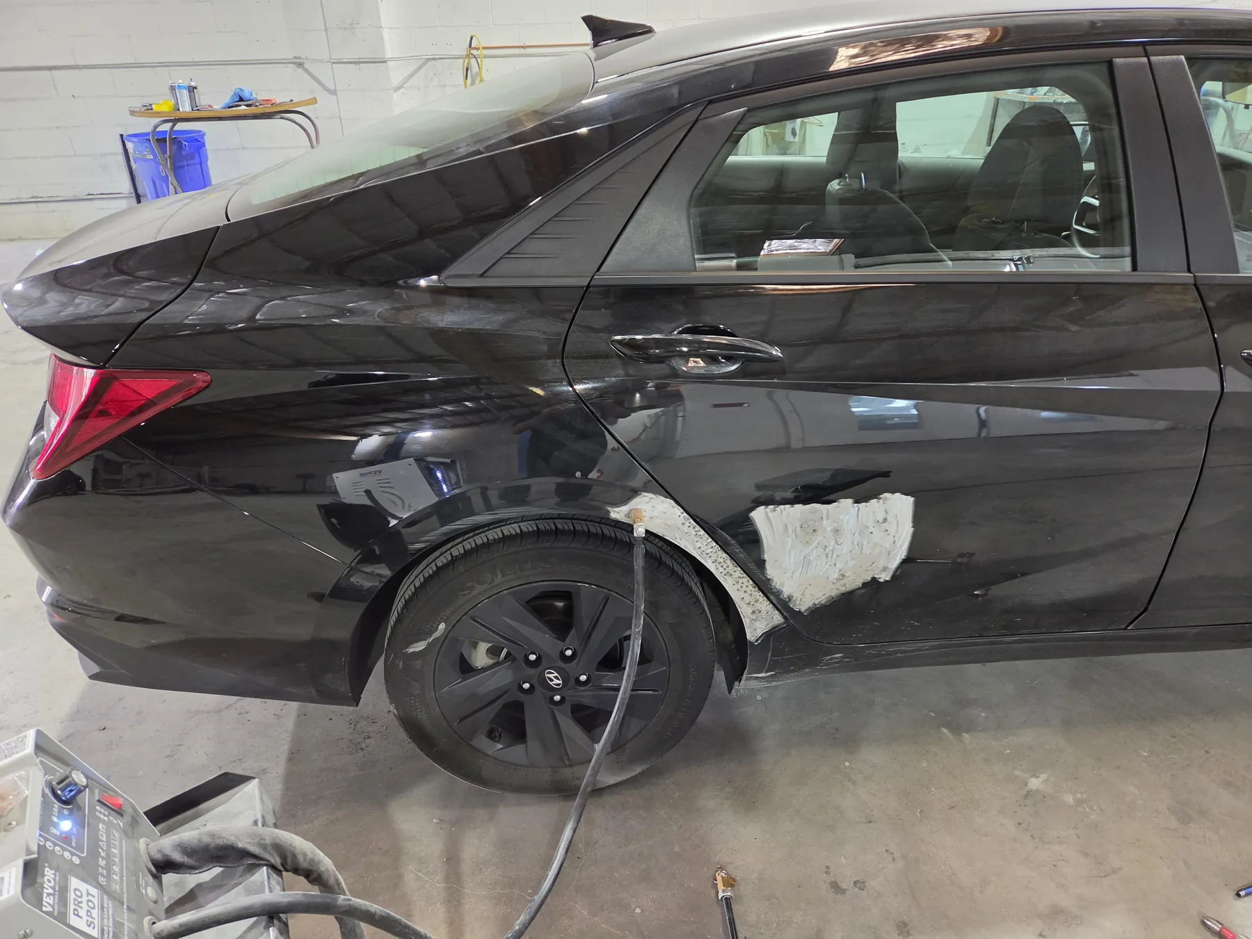 Black Hyundai rear door and quarter panel during body repair preparation